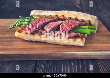 Sandwich avec asperges et tranches de steak de bœuf sur le panneau de bois Banque D'Images