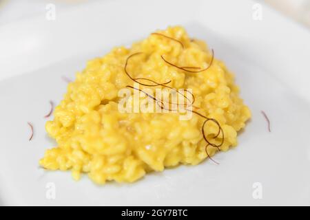 Assiette de riz au risotto jaune crémeux avec filets de safran de Milan, Italie. Banque D'Images