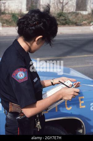 Austin Texas USA, vers 1991: Une femme hispanique de police vérifie le permis de conduire d'un automobiliste pendant un arrêt de circulation.©Bob Daemmrich Banque D'Images