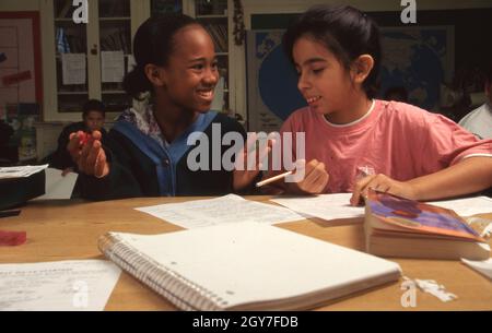 San Antonio Texas USA, octobre 1994: Les camarades de classe noirs et hispaniques de cinquième année travaillent ensemble sur les problèmes de mathématiques pendant la classe à l'école élémentaire Hawthorne.©Bob Daemmrich Banque D'Images