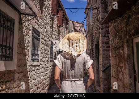 Belle blonde jeune femme voyageur portant chapeau de paille soleil visite et profiter de vacances d'été dans une vieille ville traditionnelle costale À Adriatic co Banque D'Images