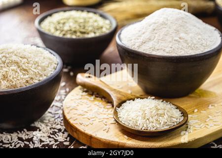 farine de riz en pot d'argile et cuillère en bois rustique, farine alternative sans gluten et plus saine Banque D'Images
