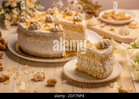 Gâteau rond avec crème fouettée et noix. Une glace est retirée et placée sur une plaque en porcelaine Banque D'Images