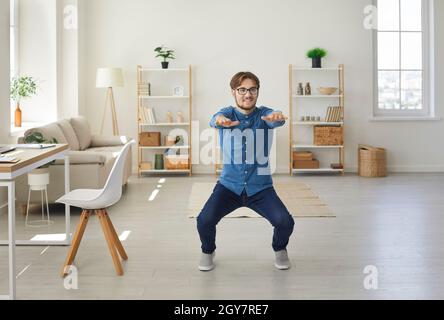 Jeune homme d'affaires actif et énergique qui fait de l'entraînement sportif dans son bureau à domicile. Banque D'Images