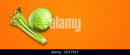Bouquet de branche de céleri et chou vert isolé sur fond de bannière orange. Vue de dessus Banque D'Images