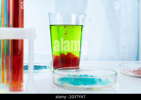 Manipulations avec des récipients de produits chimiques en verre de laboratoire sur la table Banque D'Images