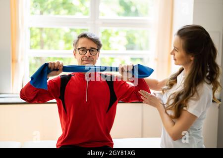 Homme âgé Estretching Rehab Physio Band avec physiothérapeute Banque D'Images