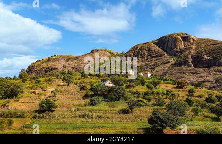 Paysage typique de Madagascar - rizières en terrasse vertes et jaunes sur de petites collines avec des maisons en argile dans la région près d'Ambositra. Banque D'Images