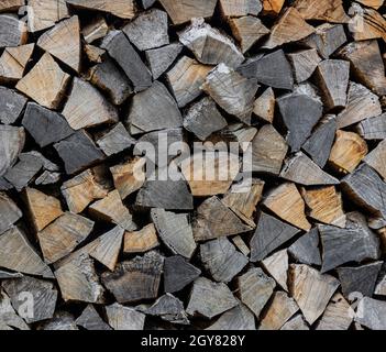 Gros plan pile de bois de chauffage sec en bois de chêne, hachés, fendus et organisés en pile pour le stock de carburant d'hiver, angle bas, vue latérale Banque D'Images