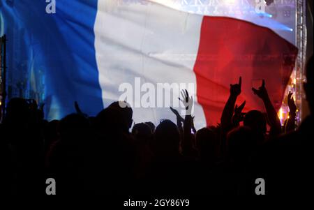 Les fans de football soutiennent la France - la foule se rend au stade avec des mains levées contre le drapeau français Banque D'Images