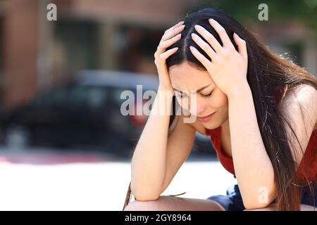 Triste femme asiatique se plaignant seule assis dans la rue Banque D'Images