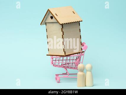 figurines de famille en bois, maison modèle. Achat immobilier, concept de location. Déménagement dans de nouveaux appartements Banque D'Images