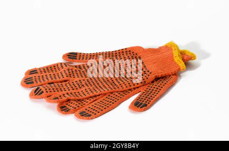 gants de travail en tissu orange sur fond blanc. Vêtements de protection pour les travailleurs manuels, gros plan Banque D'Images