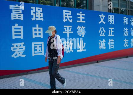 Une dame chinoise passe devant un panneau d'affichage présentant les valeurs socialistes fondamentales de la Chine à Pékin, en Chine.07 octobre 2021 Banque D'Images