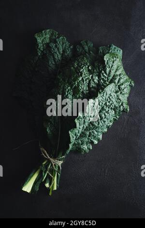 Cavolo nero noir curly kale légume sur noir Banque D'Images