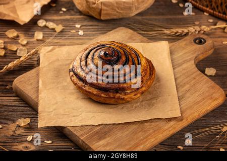 Pâte levée remplie de cacao, ayant la forme de snailhouse, produit de boulangerie sur fond rustique Banque D'Images