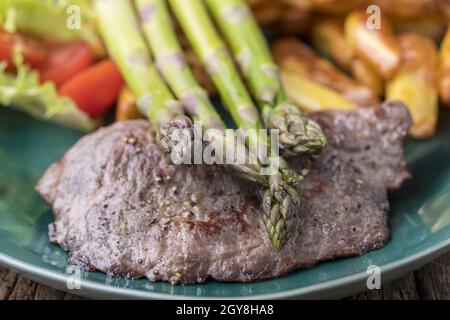 asperges sur un steak grillé avec des frites Banque D'Images