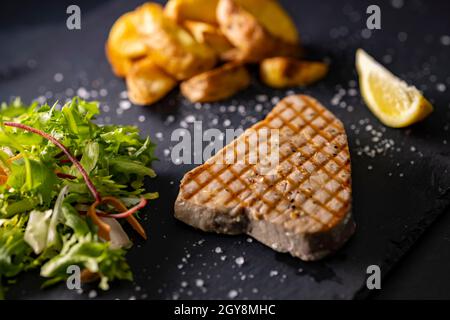 steak de thon avec salade et pommes de terre épicées Banque D'Images