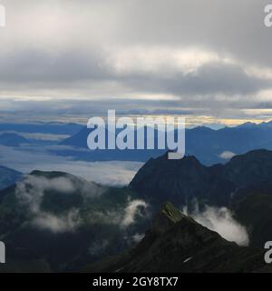 Scène au lever du soleil vue depuis le mont Brienzer Rothorn. Vue sur Stanserhorn et Lucerne. Brouillard se levant lentement après une nuit de pluie. Banque D'Images