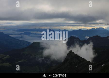 Scène au lever du soleil vue depuis le mont Brienzer Rothorn. Vue sur Stanserhorn et Lucerne. Brouillard se levant lentement après une nuit de pluie. Banque D'Images