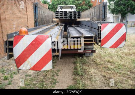 Camion de matériaux de construction chargé de poutres en acier. Notion : restrictions de longueur de charge surdimensionnée Banque D'Images