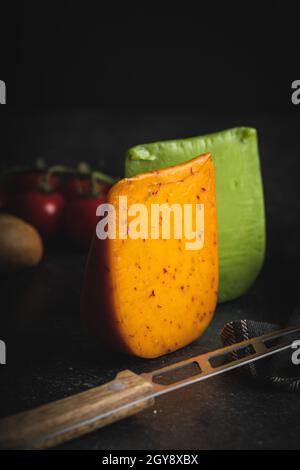 Bloc de fromage fort au piment et au wasabi sur table noire. Banque D'Images