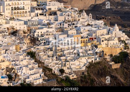 Fira, Santorini, Grèce - 27 juin 2021 : la ville blanchie à la chaux de Fira dans des rayons chauds de coucher de soleil sur l'île de Santorini, Cyclades, Grèce Banque D'Images