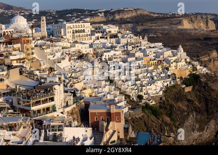 Fira, Santorini, Grèce - 27 juin 2021 : la ville blanchie à la chaux de Fira dans des rayons chauds de coucher de soleil sur l'île de Santorini, Cyclades, Grèce Banque D'Images