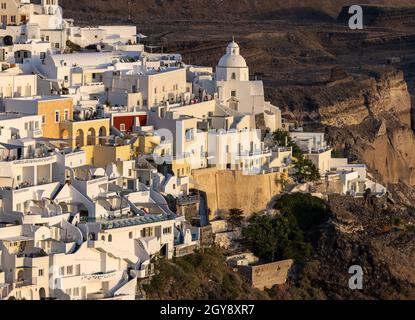 Fira, Santorini, Grèce - 27 juin 2021 : la ville blanchie à la chaux de Fira dans des rayons chauds de coucher de soleil sur l'île de Santorini, Cyclades, Grèce Banque D'Images