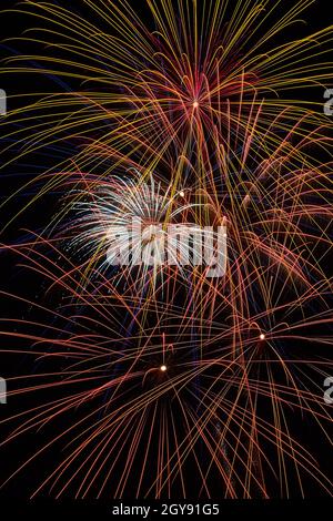 Des étincelles volent avec des feux d'artifice dans le ciel la nuit Banque D'Images