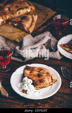 Tranche de tarte au chou avec sauce à la crème aigre sur blanc plaque Banque D'Images