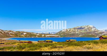 Magnifique panorama sur le lac Vavatn vue sur le paysage brut des cottages et des montagnes avec de la neige pendant l'été à Hemsedal Norvège. Banque D'Images