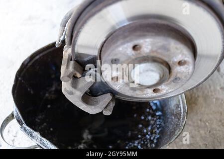 remplacement du segment de frein au-dessus du bassin par l'ancien liquide de frein de vidange dans l'atelier de voiture rurale (accent sur le nouveau segment de frein) Banque D'Images