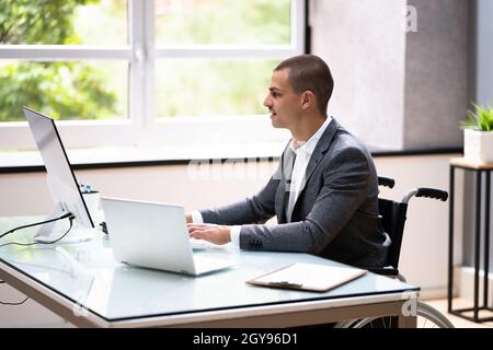 Homme d'affaires handicapé utilisant un ordinateur portable au bureau Banque D'Images