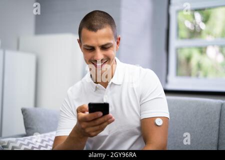 Homme utilisant le capteur de diabète de la surveillance à distance continue de glucose Banque D'Images