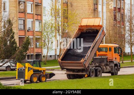 Le déchargement du camion-benne d'industrie lourde de l'asphalte chaud .ville La construction de routes et le renouvellement du Banque D'Images