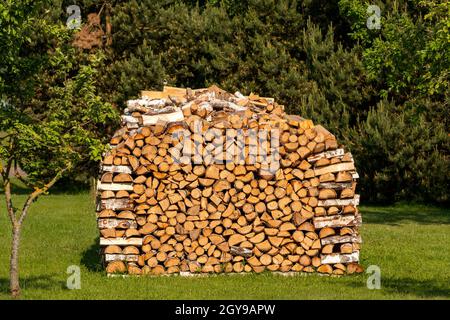 Pile de bois de chauffage se dessécher le jour ensoleillé d'été. Préparation de bois de chauffage pour l'hiver. Banque D'Images