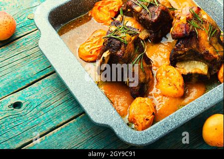 Côtes de bœuf à l'abricot. Viande de veau avec sauce aux fruits sur fond de bois rustique Banque D'Images