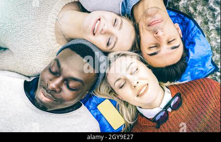 Vue de dessus des meilleurs amis multiraciaux se reposer ensemble en plein air le jour ensoleillé - amitié heureuse et concept de paix Banque D'Images