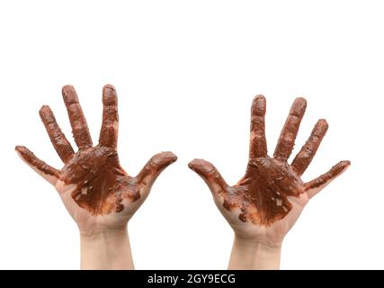 deux mains femelles sont sales dans du chocolat noir fondu sur un fond blanc, la partie sale du corps est relevée Banque D'Images