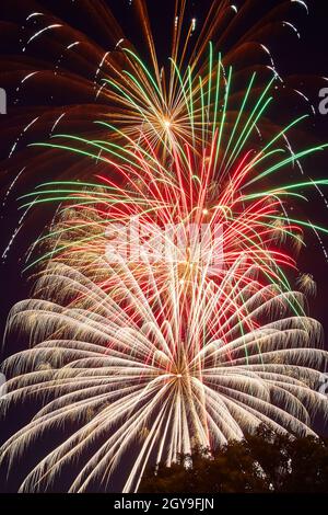 Éclats d'étincelles avec feux d'artifice blancs, roses et verts la nuit Banque D'Images