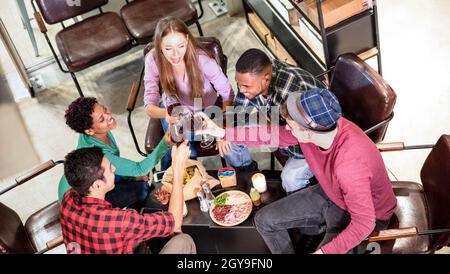 Vue de dessus des amis multiraciaux qui goûte du vin rouge et s'amusent au bar à la mode de l'établissement vinicole - Multicultural tendance Friendship concept Banque D'Images