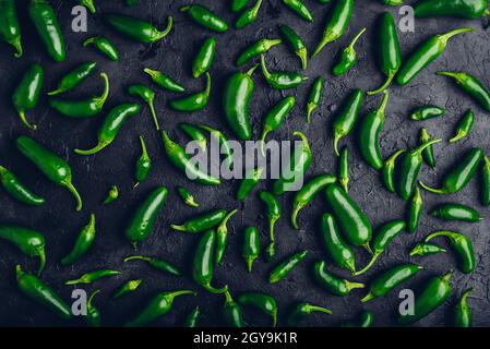 Vue de dessus de Peppers de Jalapeno vert sur fond de béton noir Banque D'Images