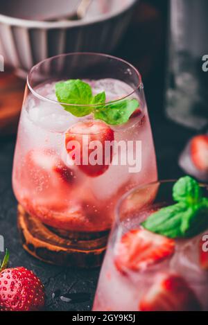 Deux verres de cocktail avec des fraises fraîches et congelées, du gin et du tonique Banque D'Images