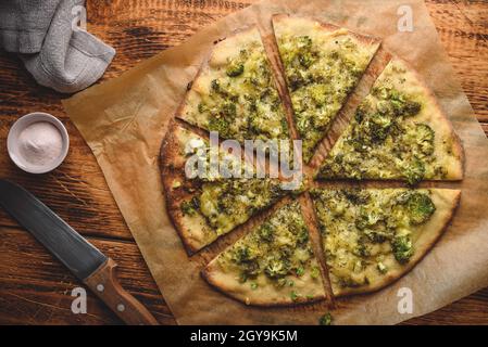 Pizza cuite avec brocoli, pesto, herbes et fromage sur une table en bois. Vue de dessus Banque D'Images