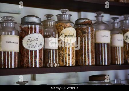 Épices et herbes dans des bouteilles rustiques et étiquetées sur une étagère Banque D'Images