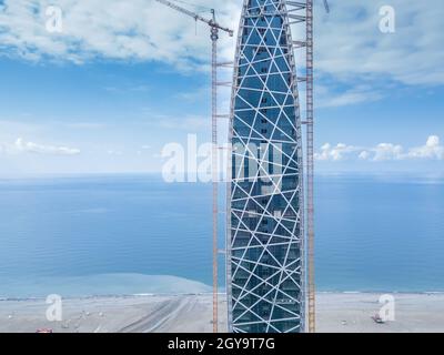 Vue rapprochée du côté du drone sur le chantier de construction d'un hôtel de plusieurs étages sur le fond de la mer à Batumi. Banque D'Images