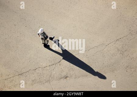 Femme traversant la rue, vue de dessus, longue ombre sur l'asphalte.Concept de sécurité routière Banque D'Images