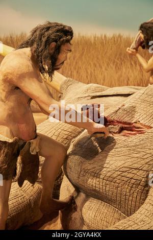 Réplique de l'homme préhistorique qui reçoit de la nourriture d'un animal au Musée Paléontologique de Cuenca, Castilla la Mancha, Espagne Banque D'Images