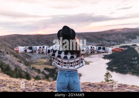 Vue arrière d'une femme se tenant près du lac et des montagnes tranquilles en hiver Banque D'Images